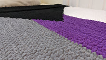Load image into Gallery viewer, A close up view of the stitches on the demisexual pride flag blanket, which is sitting on a twin-sized bed